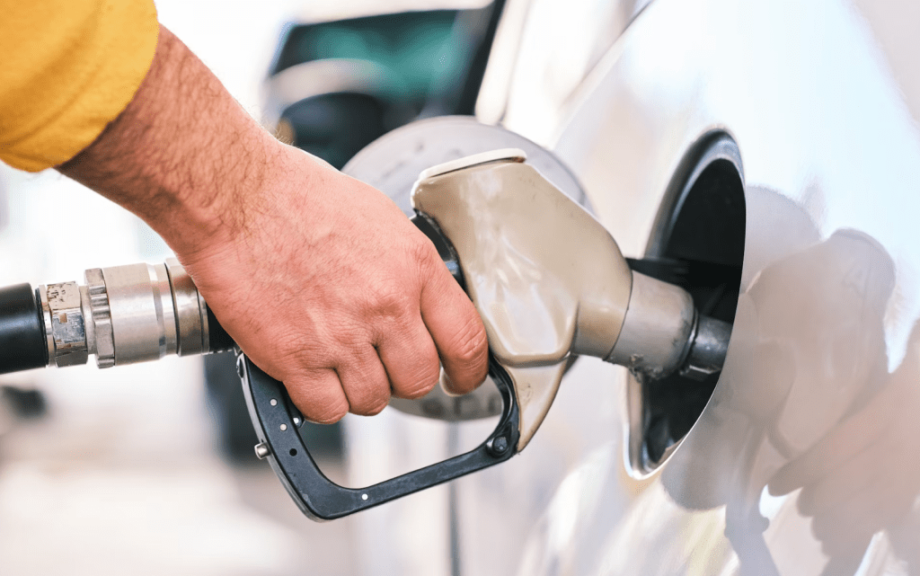 Closeup of man pumping gasoline fuel in car at gas station. Engin Akyurt/Unsplash